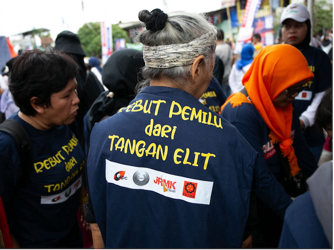 Several residents wore t-shirts that read ‘Seize the Election from the Elite’ during the signing of the political contract between the Urban Poor People’s Network (JRMK) and then presidential candidate Anies Baswedan, ahead of the presidential election on 14 February 2024. It was the last political contract signed by JRMK. /Project Multatuli/Adrian Mulya.